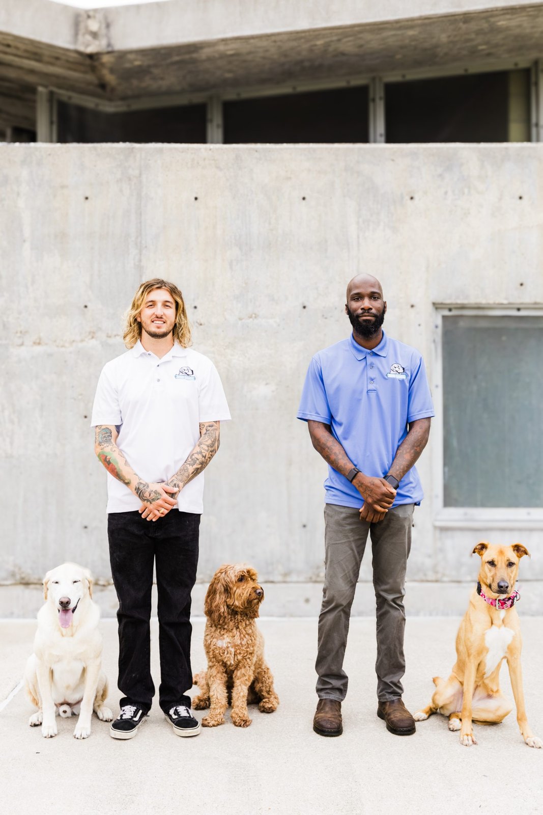 Wesley Dawe and Anthony Mason standing outdoors with three dogs