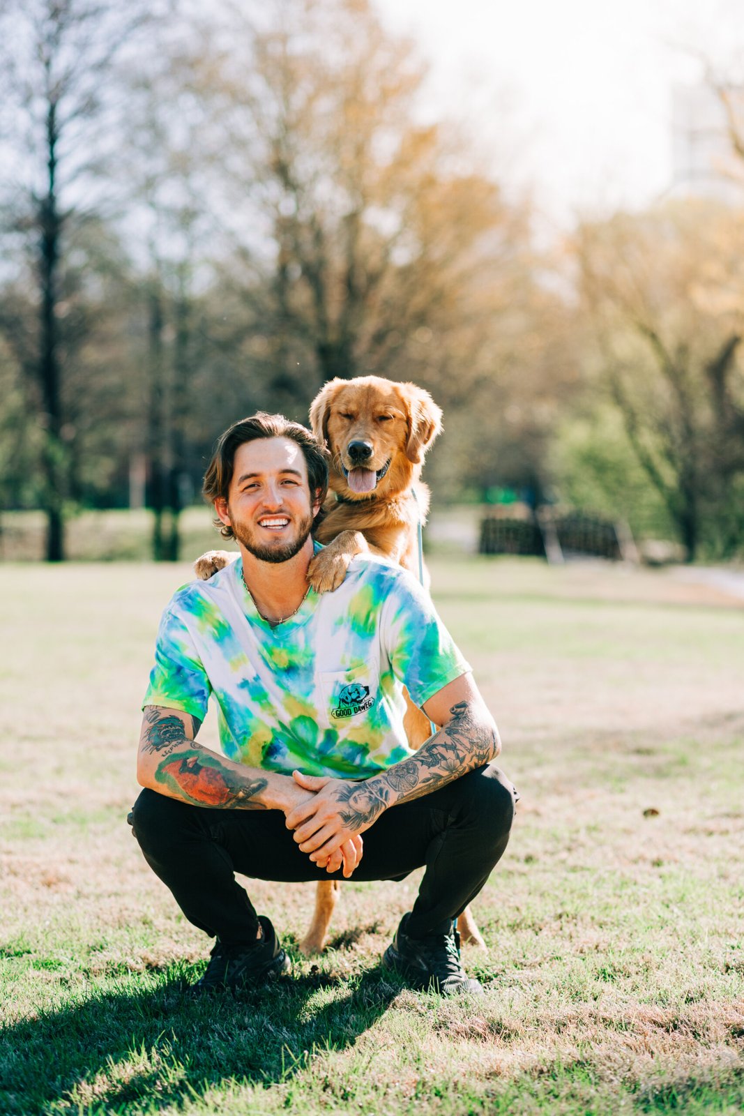 Wesley Dawe outdoors with a golden retriever resting its paws on his shoulders