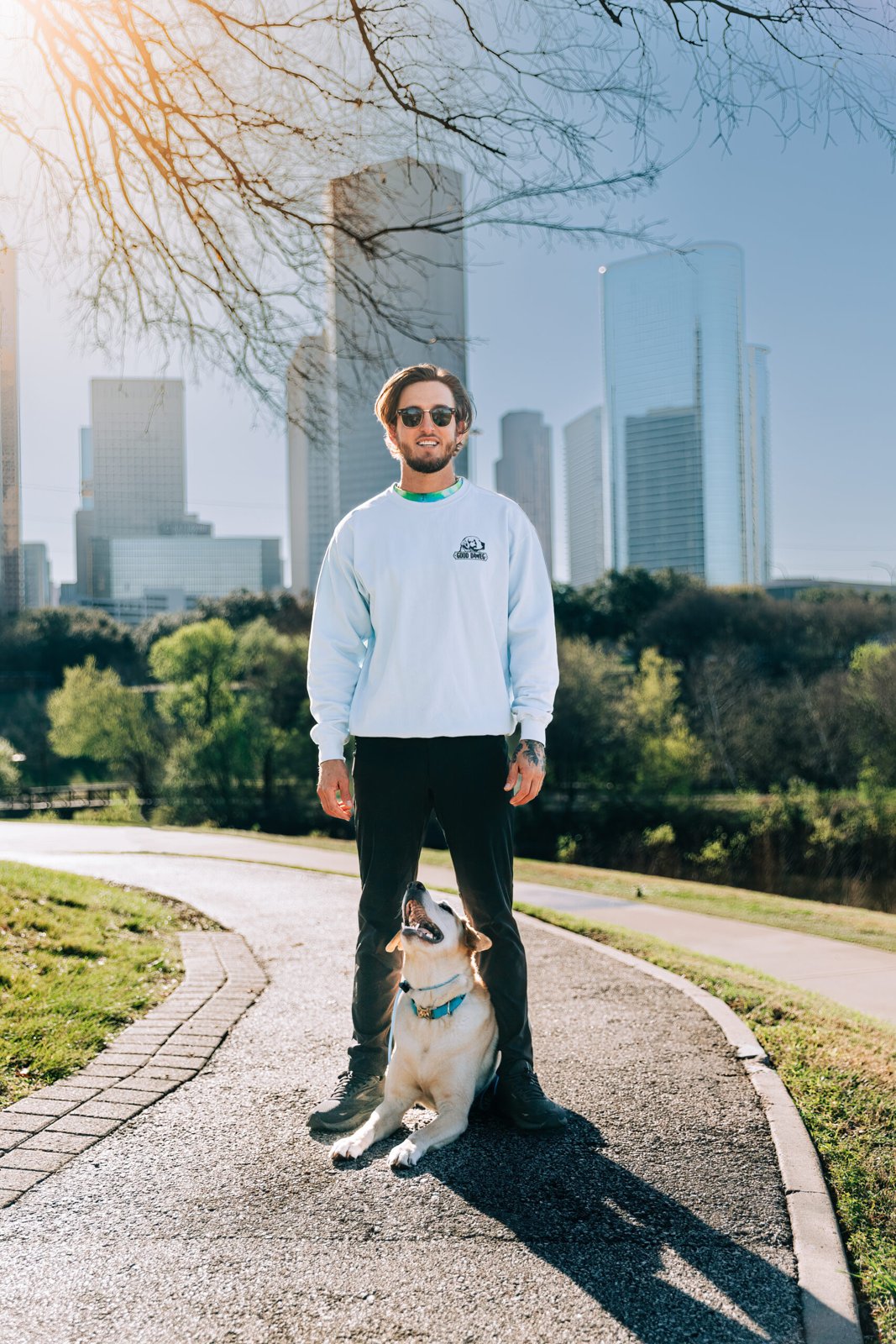 Wesley Dawe and a dog on a trail with Houston buildings behind them Wesley Dawe and a dog on a trail with Houston buildings behind them